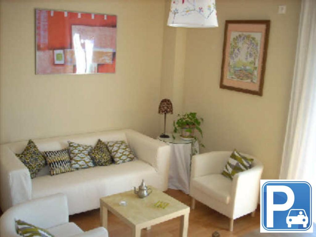 een woonkamer met een witte bank en een tafel bij VTV San FranciscoCentroMezquita in Córdoba