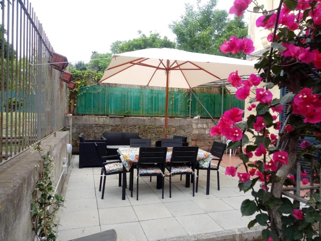 un patio con tavoli, sedie e ombrellone di Casa vacanze Sofia a Piano di Sorrento