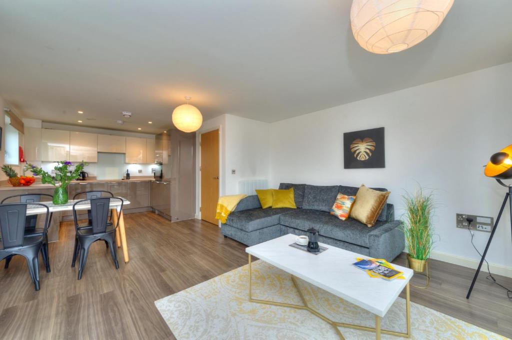 Executive Oakgrove Apartment by PAY AS U STAY في ميلتون كينز: غرفة معيشة مع أريكة وطاولة