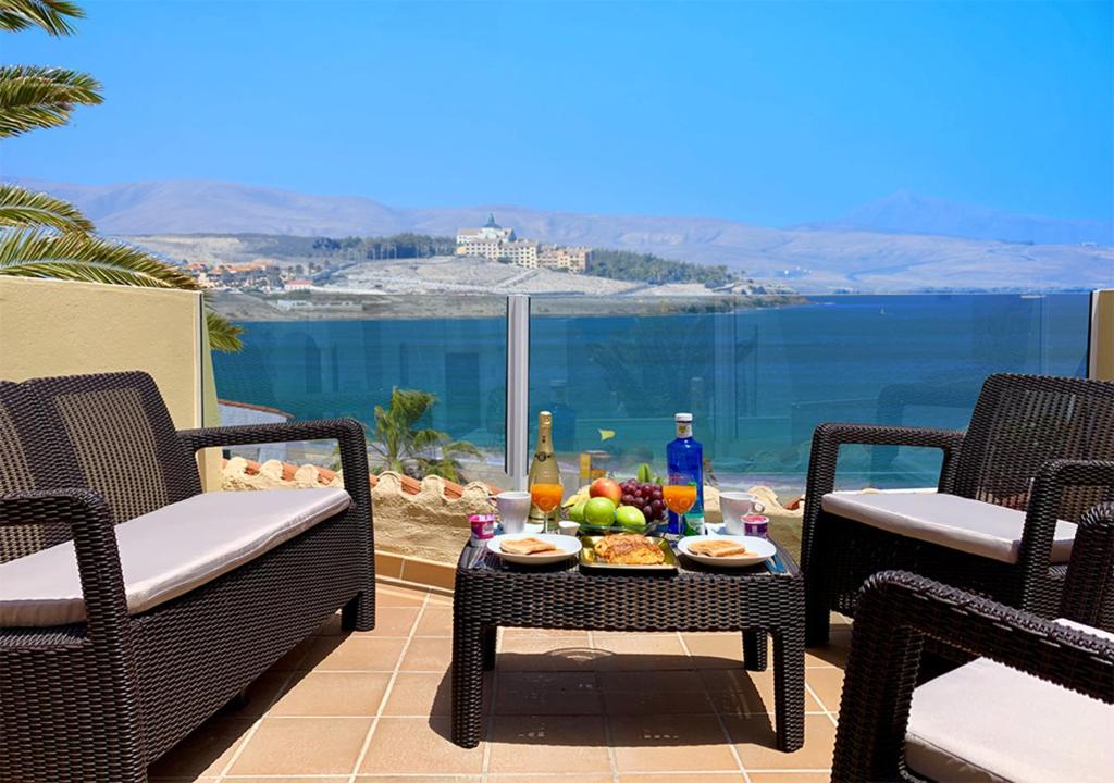 コスタ・カルマにあるApartamentos Fuerteventura Solのパティオ(椅子2脚、テーブル、食べ物付)