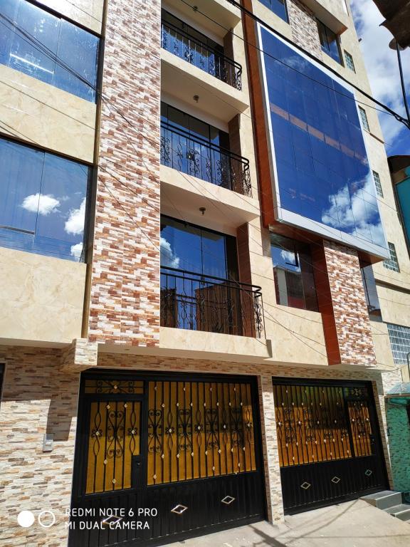 un edificio con dos juegos de puertas y ventanas en INTI SUMAQ WASI en Cusco