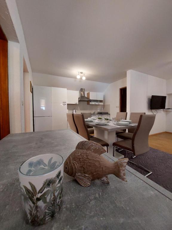 kuchnia i jadalnia ze stołem, na którym stoi ryba w obiekcie Sofija apartmani w mieście Vir