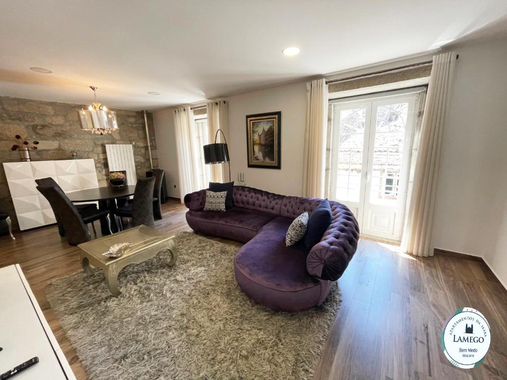 - un salon avec un canapé violet et une table dans l'établissement Apartamento da Seara "Lamego", à Lamego