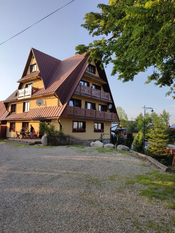 un grande edificio con tetto di paglia di Tatrzańskie Kwatery a Bukowina Tatrzańska