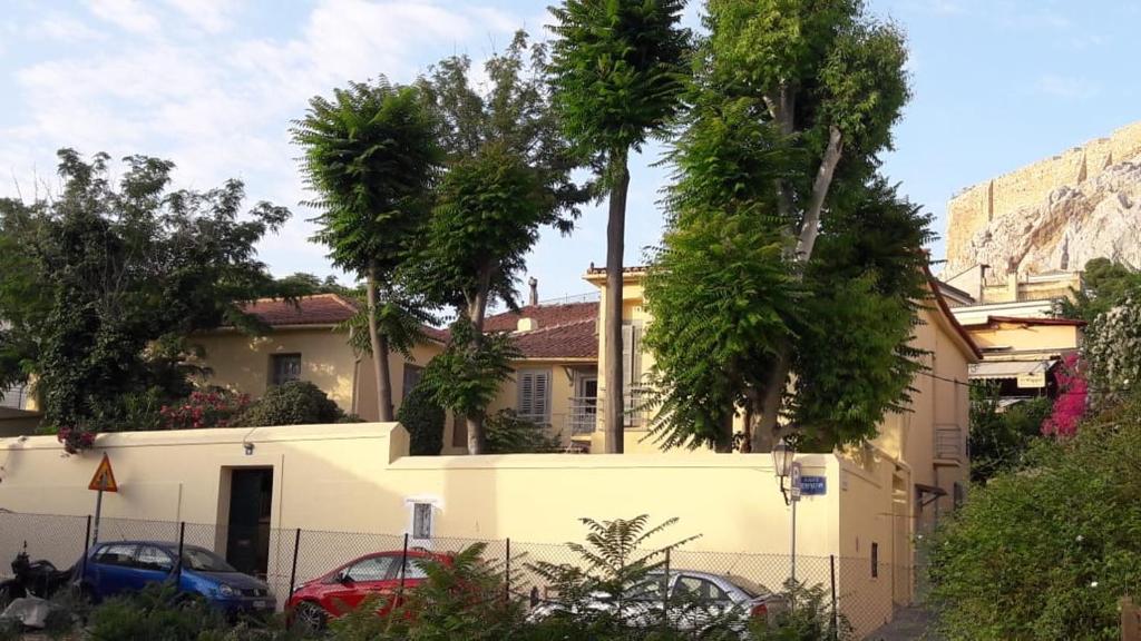 uma casa com palmeiras em frente a uma cerca em A Painter's House in Plaka em Atenas