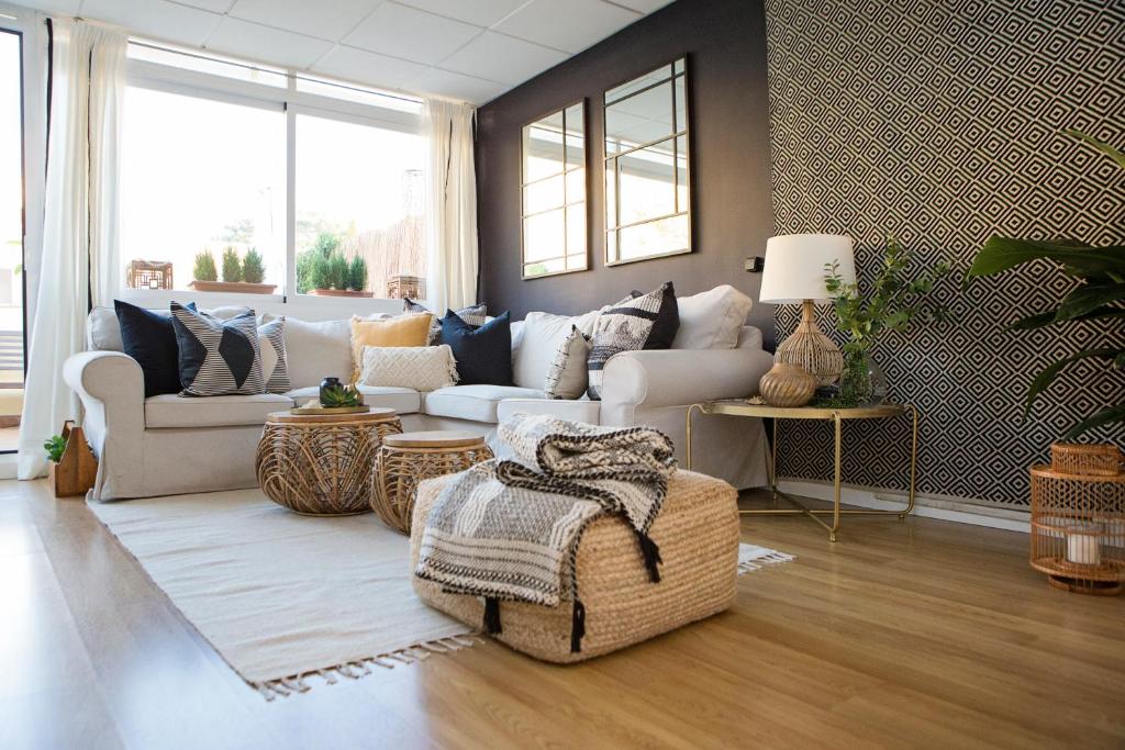 ein Wohnzimmer mit einem Sofa und einem Tisch in der Unterkunft Sol y Malaga - Designer Duplex con Terraza y Parking in Málaga