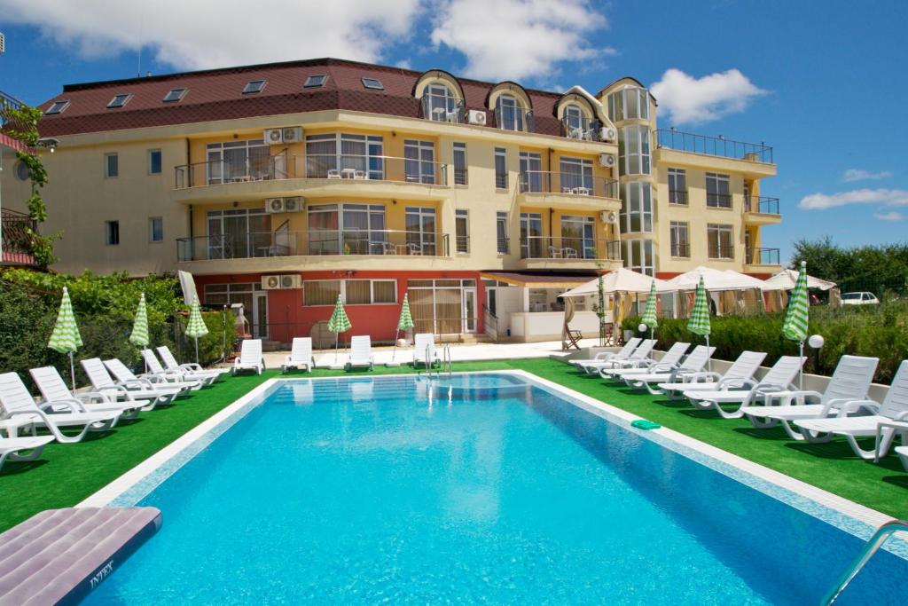 un hotel con piscina, sillas y un edificio en Aparthotel Anixi, en Obzor