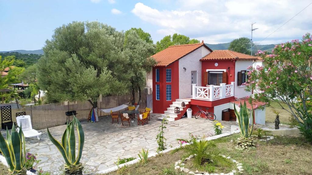 a red and white house with a patio at Vanna's Holiday House in Ierissos