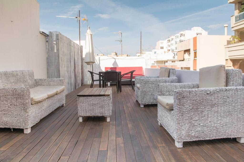 terraza con sillas de mimbre y mesas en el balcón en Hostal Ibiza, en Ibiza