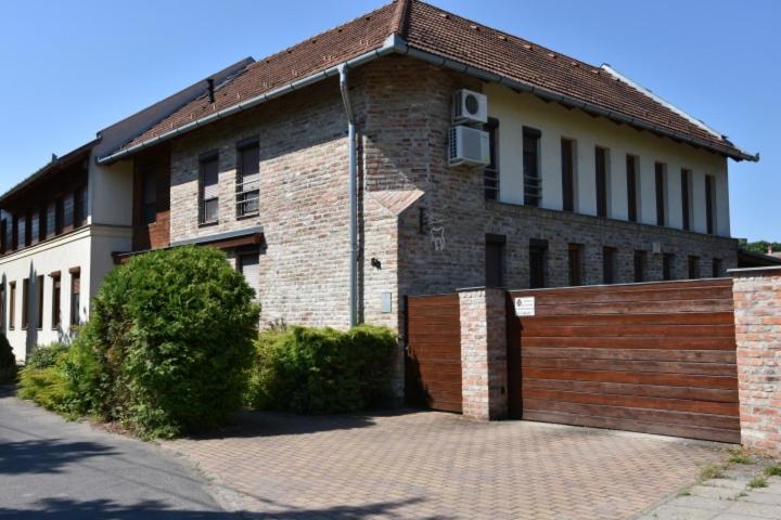 a brick building with a gate in front of it at A-Boutique Apartman Gyula in Gyula