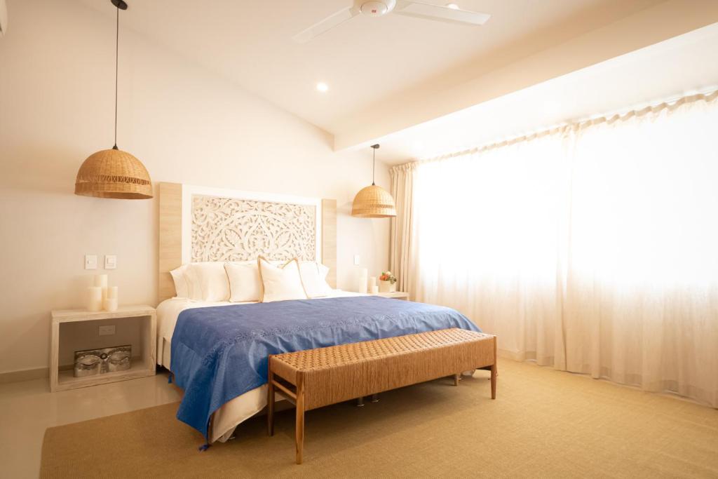 1 dormitorio con 1 cama con manta azul y ventana en Hotel Mandalas House by DOT Boutique en Santa Marta