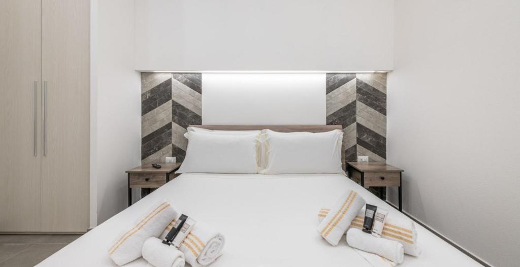 a bedroom with a large white bed with two pillows at Ichnusa Rooms in Cagliari