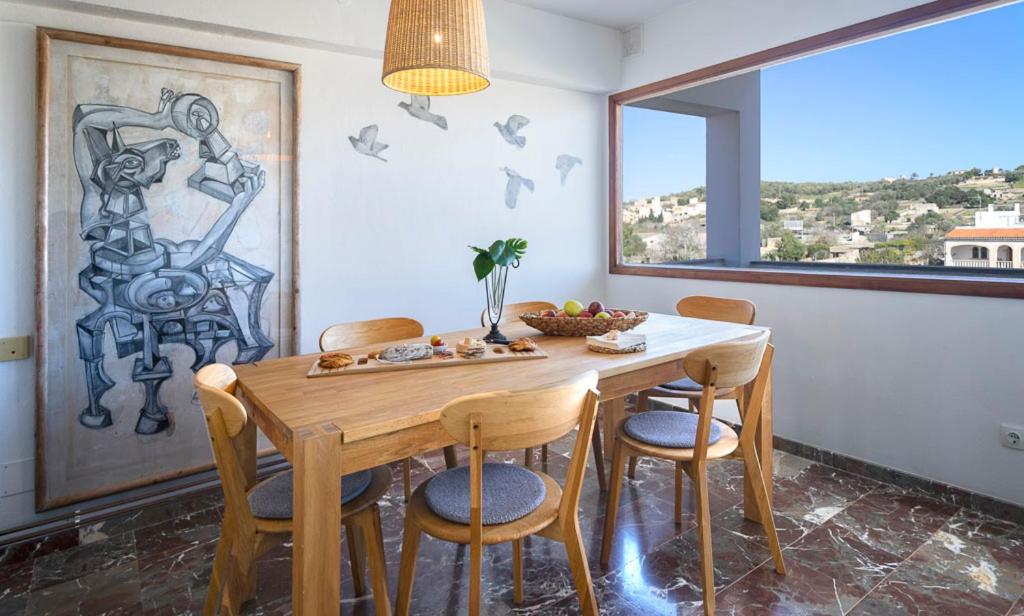 a dining room with a wooden table and chairs at BENNÁSSAR 2 in Felanitx