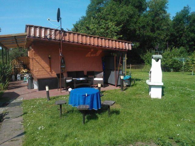 a house with a table and a dress in the grass at kleines-Ferienhaus-nur-5-Auto-min-von-Binz in Lubkow