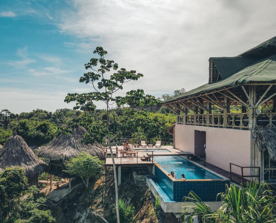 a resort with a swimming pool and a building at The Journey Hostel in Los Naranjos