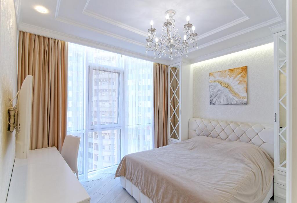 um quarto com uma cama e um lustre em Прекрасные апартаменты в Аркадии em Odessa