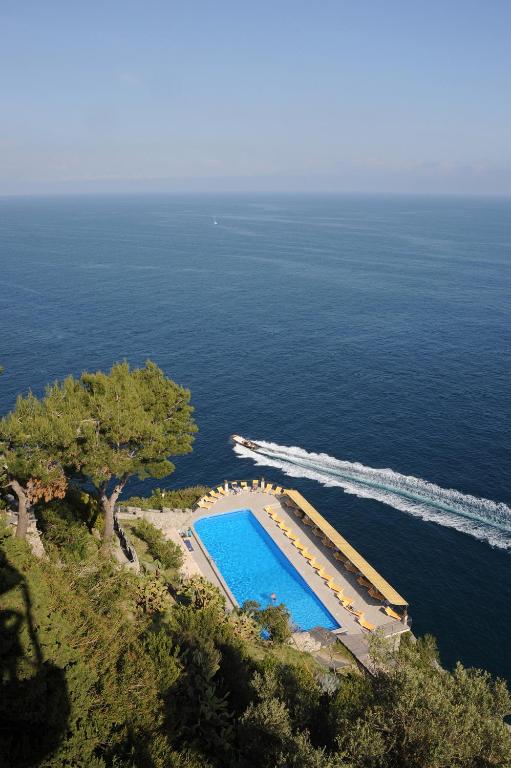 an overhead view of a swimming pool next to the ocean at Hotel Belvedere in Conca dei Marini