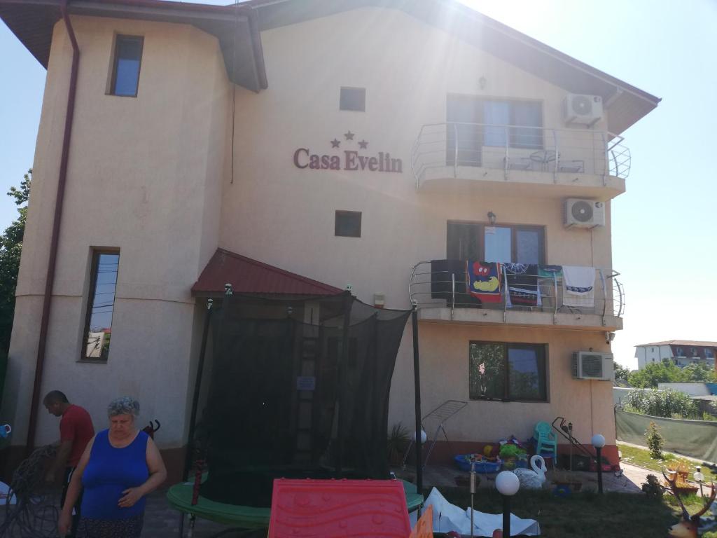 a woman standing in front of a building at Casa evelin 2mai in 2 Mai