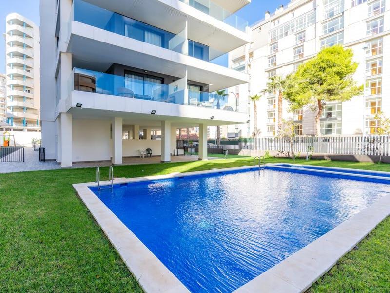 a house with a swimming pool in front of a building at Calpe Beach II - sea & pool view apartment in Calpe