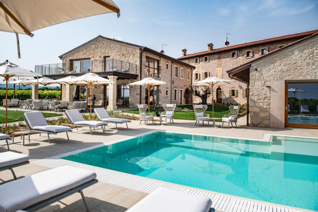 a villa with a swimming pool and patio furniture at Magari Estates Hotel in Colognola ai Colli