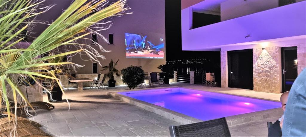 una grande piscina in una casa con illuminazione viola di Villa Kajgo-Pag a Pag