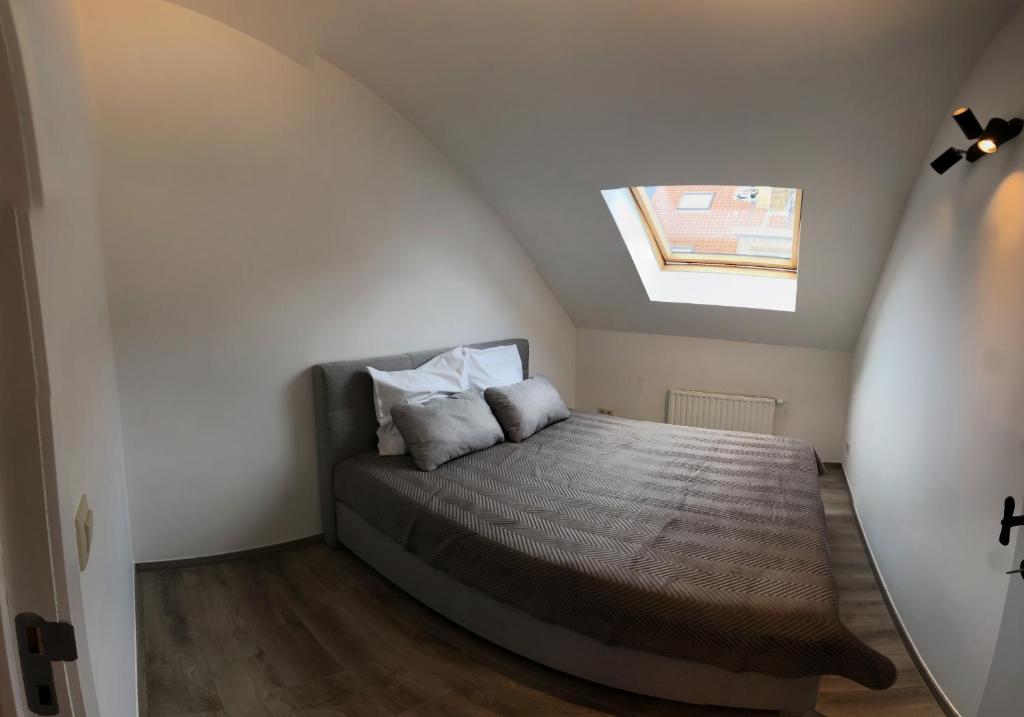 ein Schlafzimmer mit einem Bett im Dachgeschoss in der Unterkunft Suite Christina in Ostende
