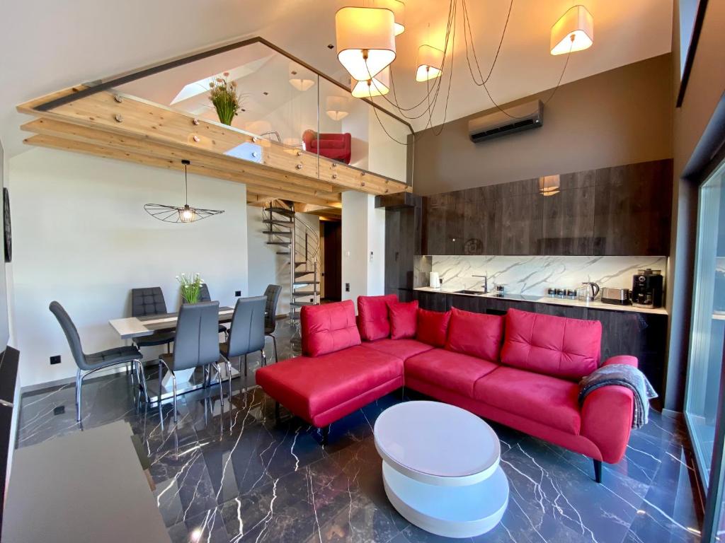 uma sala de estar com um sofá vermelho e uma mesa em Apartament LUX Ustroń em Ustroń