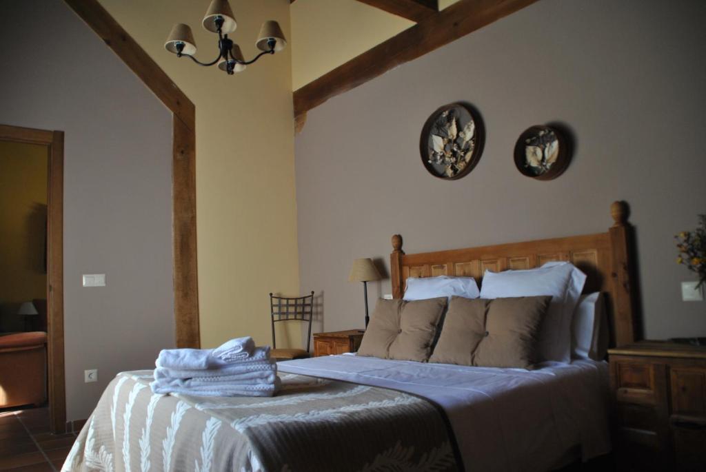 Un dormitorio con una cama con toallas. en Casa Rural El Regajo, en Tenzuela