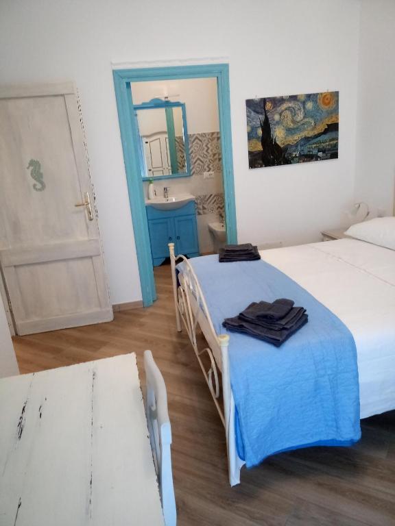 sypialnia z 2 łóżkami, lustrem i drzwiami w obiekcie ASFODELIA-CAVALLUCCIO w mieście Alghero