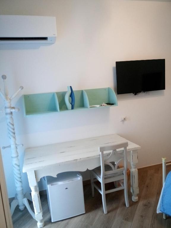 białe biurko z telewizorem na ścianie w obiekcie ASFODELIA-CAVALLUCCIO w mieście Alghero