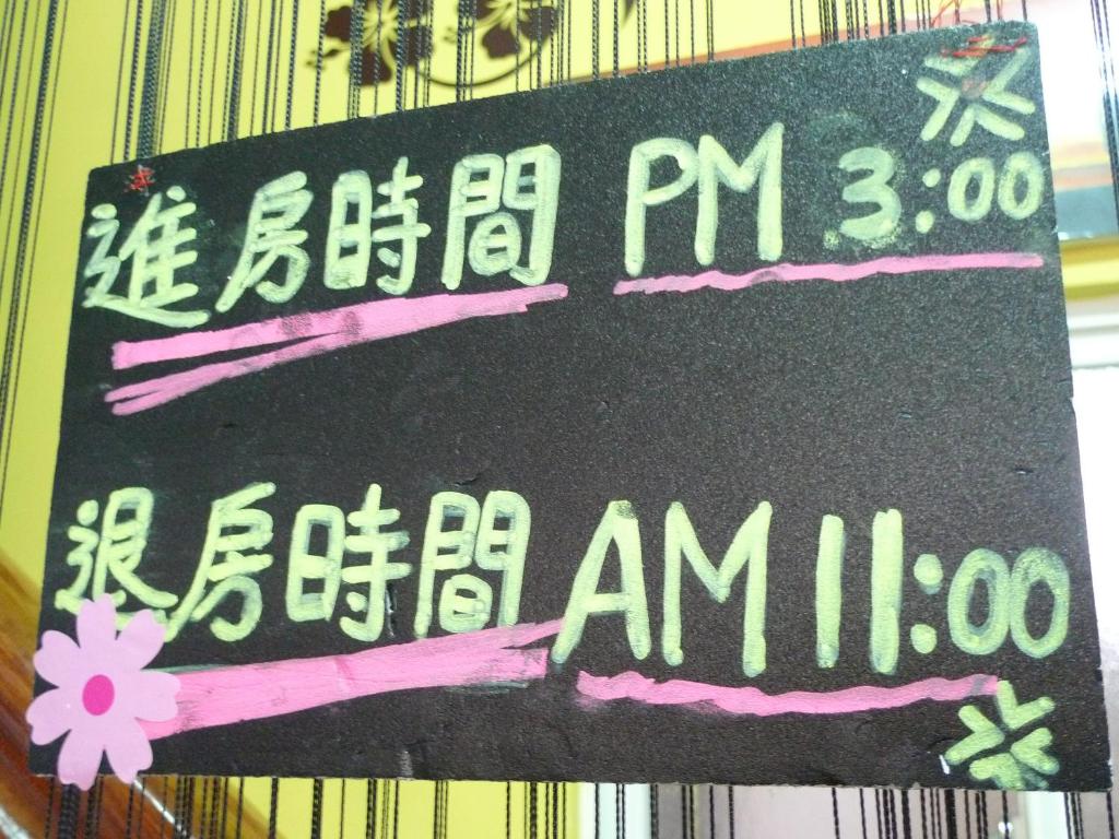 a sign that is hanging on a wall at Rihchun Homestay in Hengchun South Gate