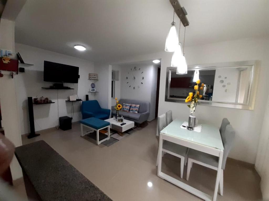 ein Wohnzimmer mit einem Tisch und einem blauen Stuhl in der Unterkunft Apto cómodo, confortable para descansar y Disfrutar in Cartagena de Indias
