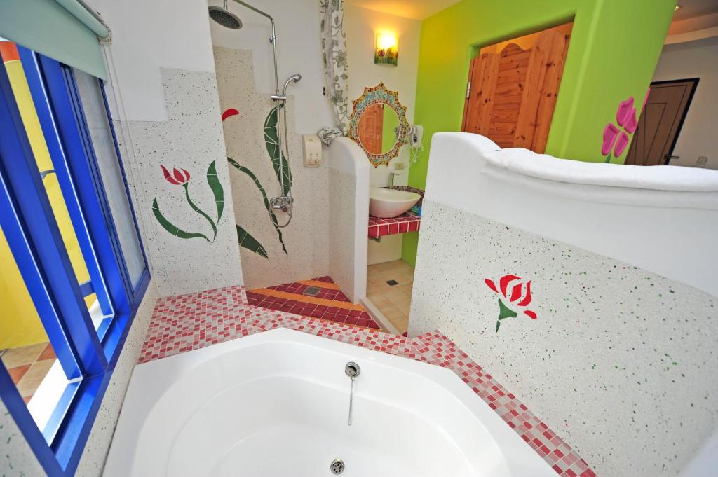 a bathroom with a tub and a toilet and a sink at Haisu Homestay in Eluan