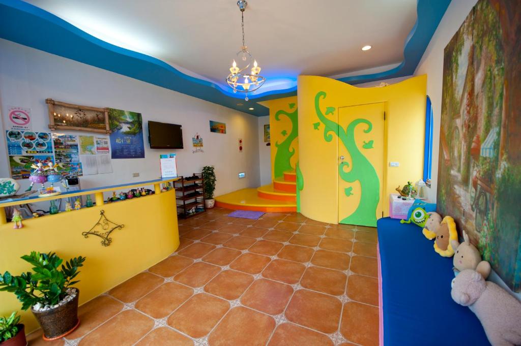 a childs room with a playroom with yellow and blue walls at Haisu Homestay in Eluan