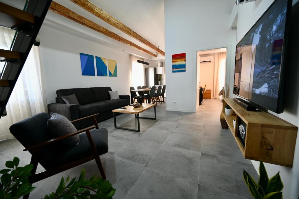a living room with a couch and a tv at Apartments Porta Maggiore in Koper