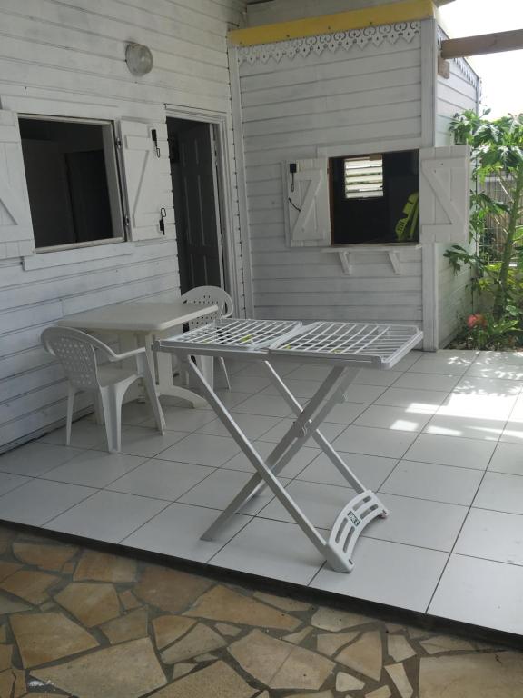 una mesa y sillas en un patio en Très belle location touristique, en Sainte-Anne