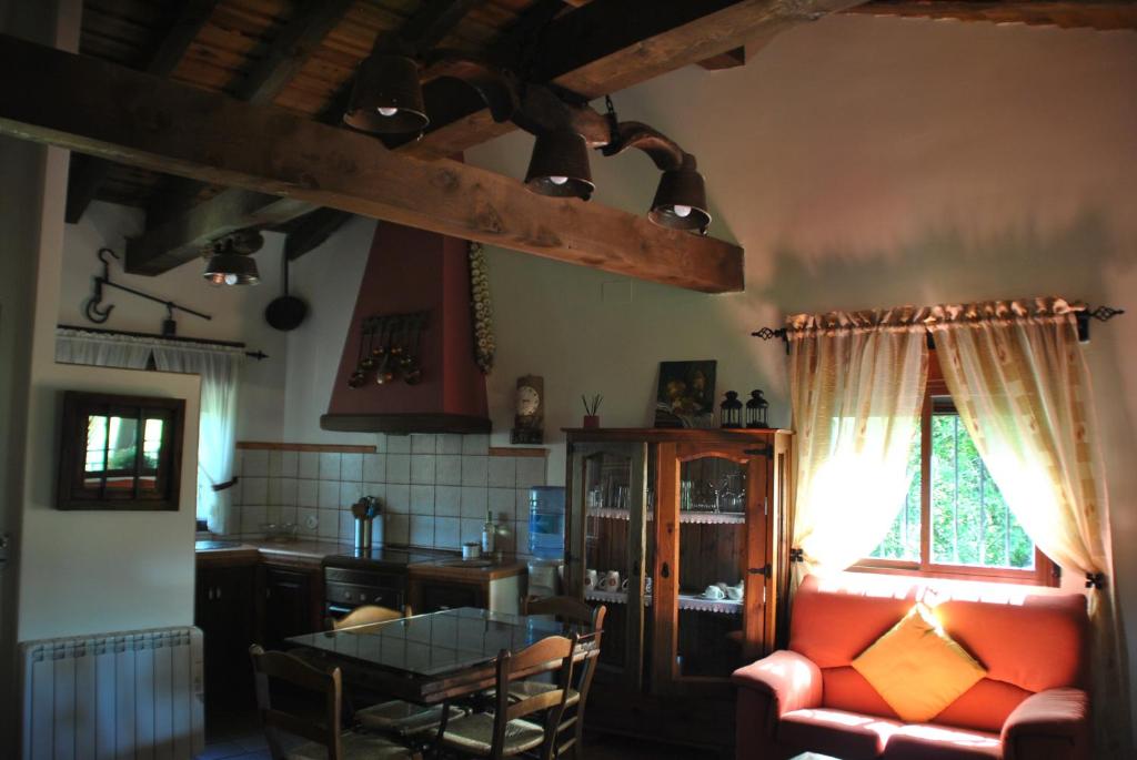 a living room with a red couch and a table at Casa Rural Los Regajales in Tenzuela