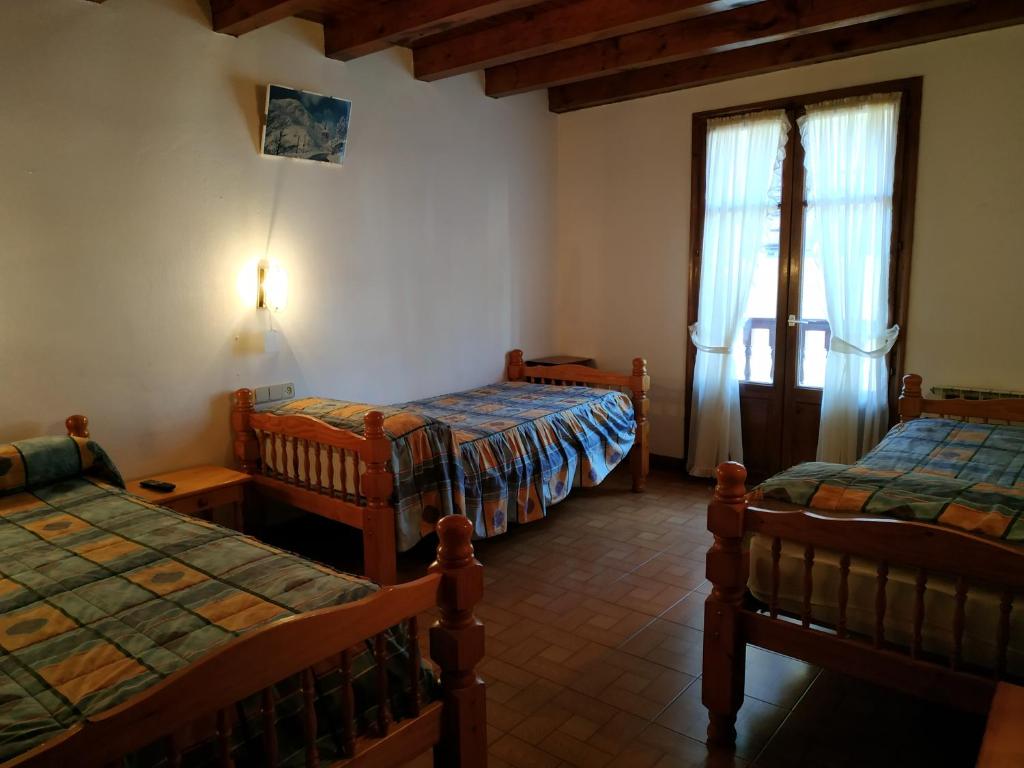 a room with two beds and a window in a room at Pension casat in Salardú