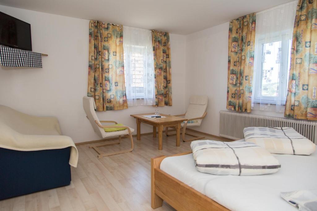 1 Schlafzimmer mit 2 Betten, einem Tisch und Stühlen in der Unterkunft Gästehaus Grasch in Kitzeck im Sausal