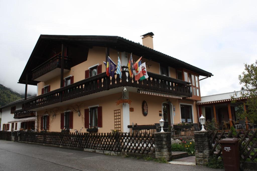 um edifício com bandeiras na frente em Hotel Garni Otto Huber em Oberammergau