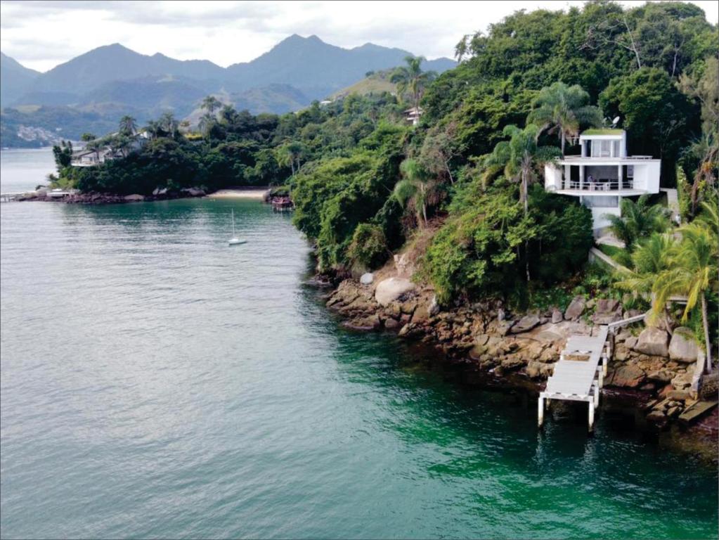 a house on a hill next to a body of water at Astangra Residence in Angra dos Reis
