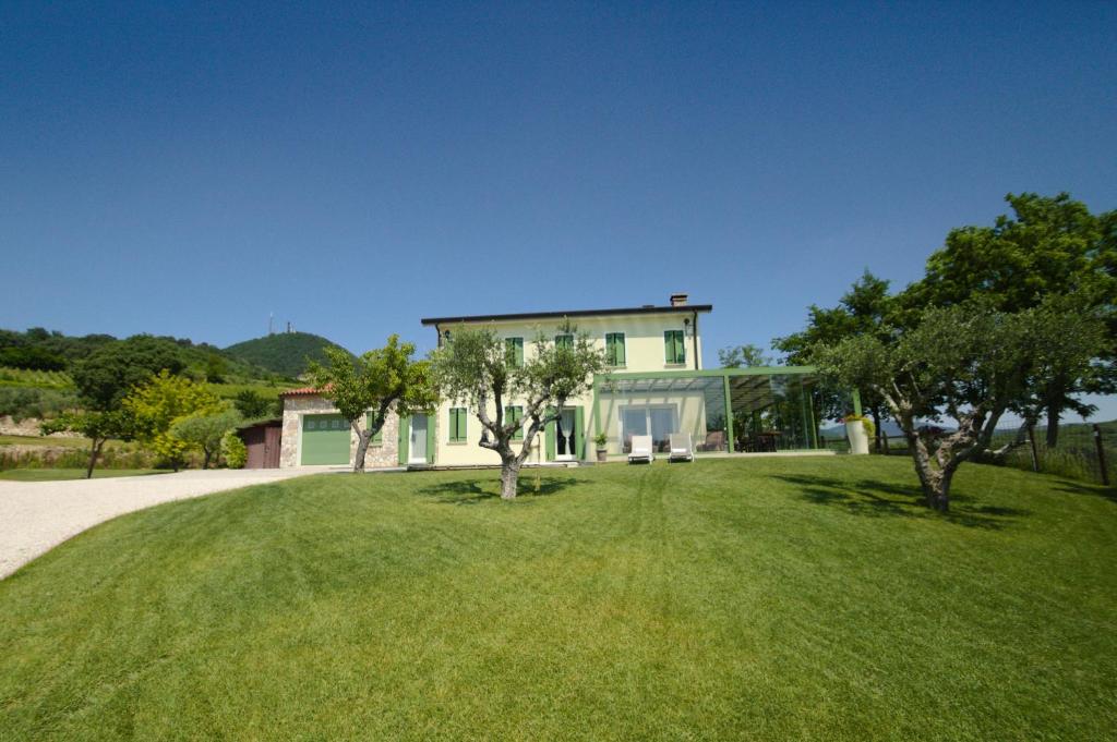 a house with a green yard with trees at B&B Ai Filari in Baone