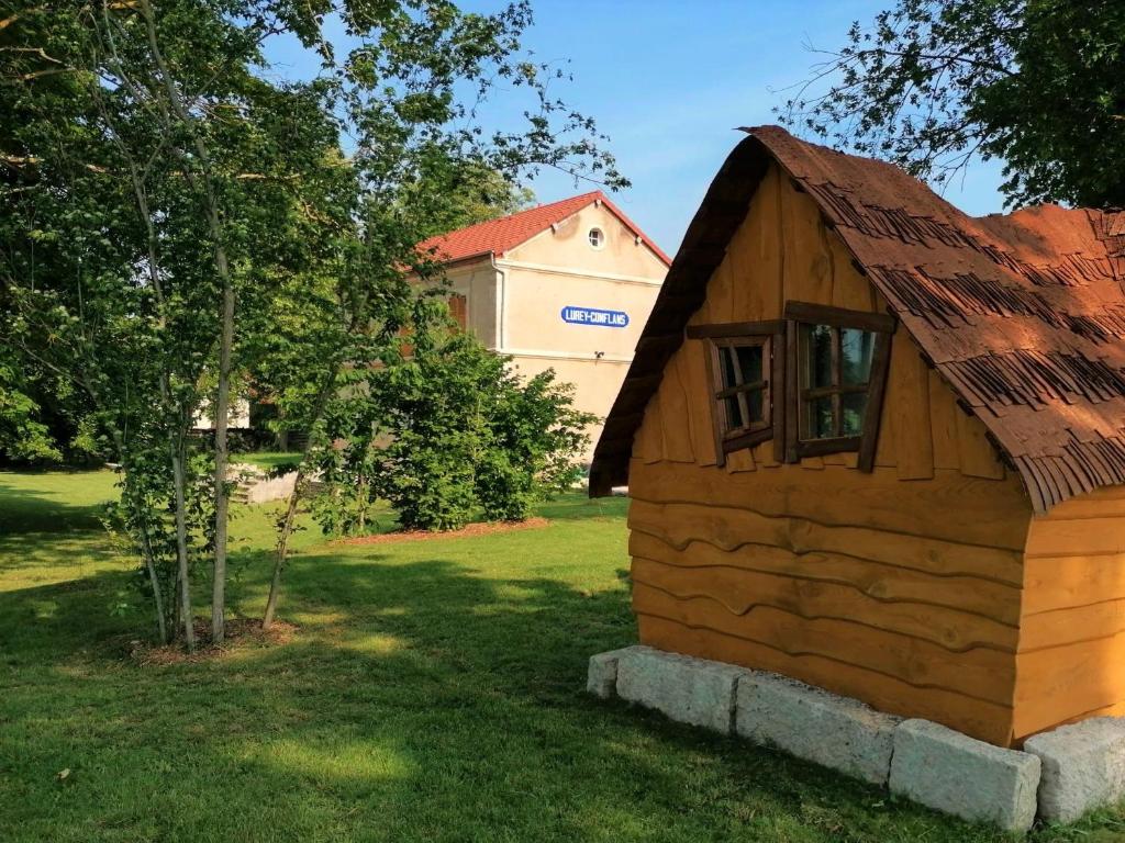 a small wooden house with a roof on the grass at La Gare de Lurey Conflans gîte et hébergements insolites en Champagne in Esclavolles-Lurey