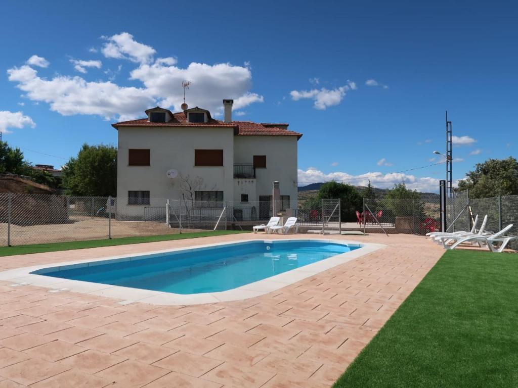 eine Villa mit einem Pool vor einem Haus in der Unterkunft El Mirador Apartamentos in El Barraco