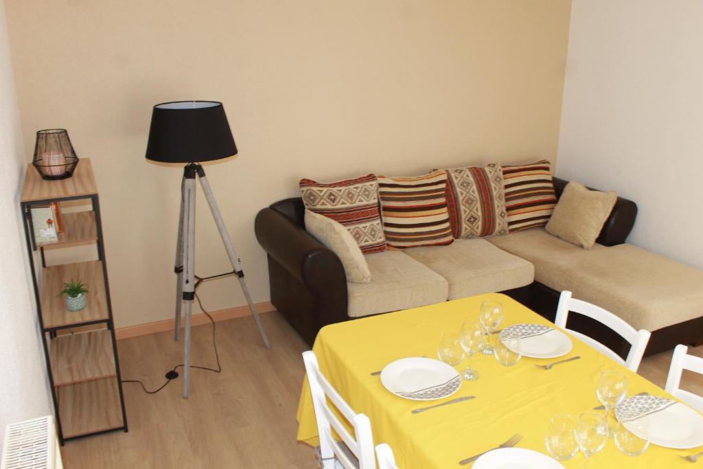 Gite de l'ancien Moulin في لو فال ديه آجول: غرفة معيشة مع طاولة صفراء وأريكة
