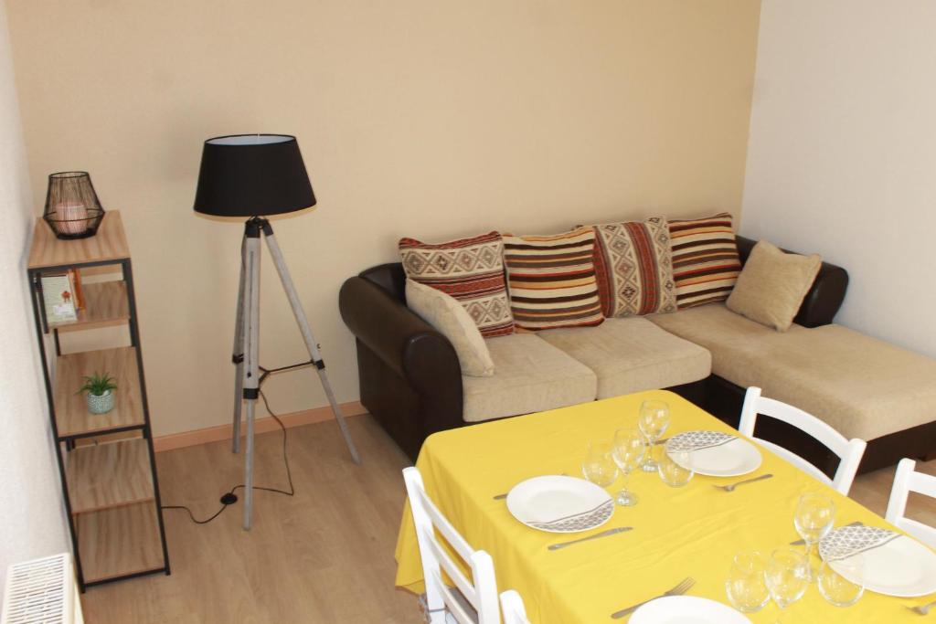 a living room with a yellow table and a couch at Gite de l'ancien Moulin in Le Val-dʼAjol