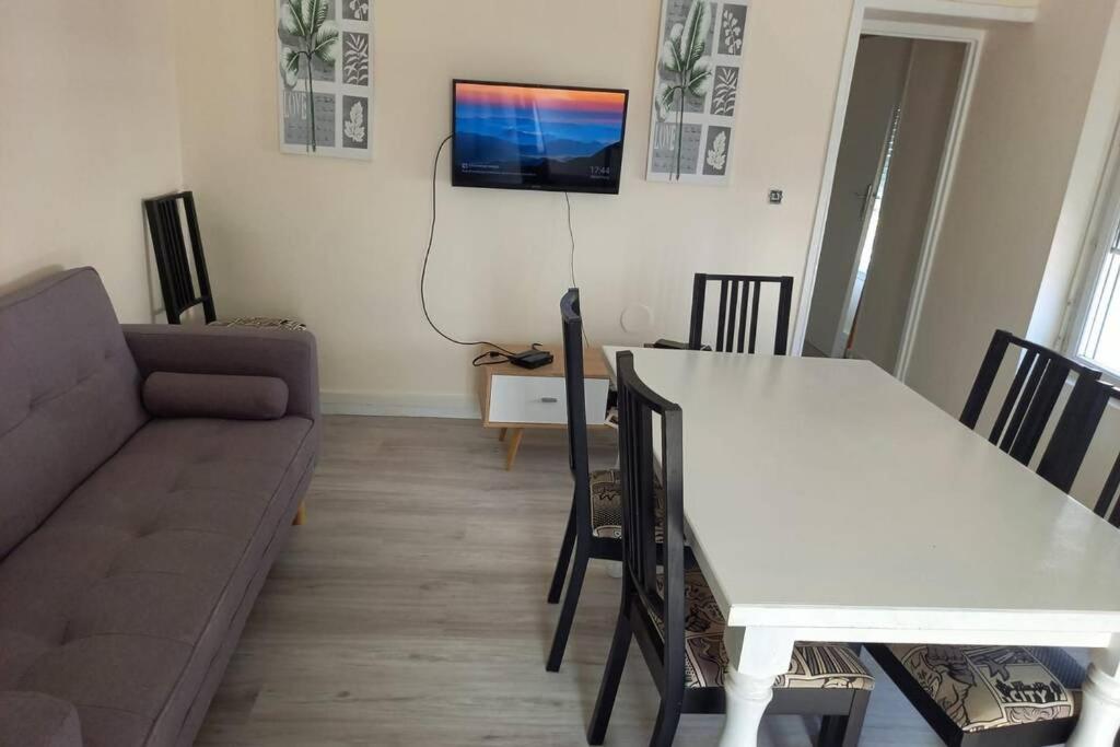 un salon avec une table blanche et un canapé dans l'établissement F3 5 personnes proche de Paris, à Coubron