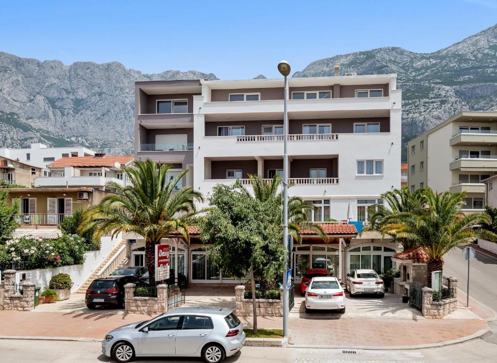 a parking lot with cars parked in front of a building at Apartments Dany in Makarska