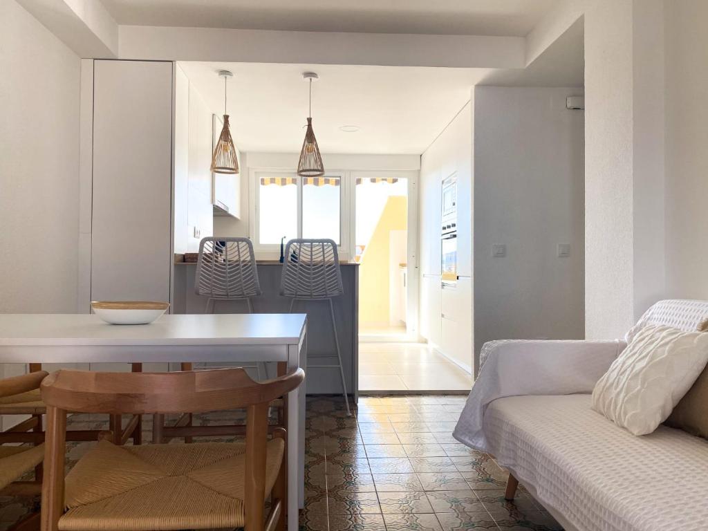 uma cozinha e sala de estar com uma mesa e um sofá em Nuevo apartamento en Gandía con vistas al mar em Playa de Gandia