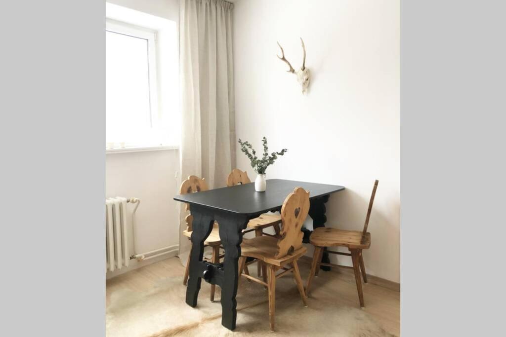 einem schwarzen Esstisch mit Stühlen und einem Fenster in der Unterkunft Apartmán Strnadovy Boudy in Železná Ruda